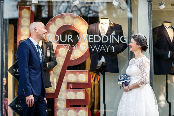 Bride and groom outside wedding shop