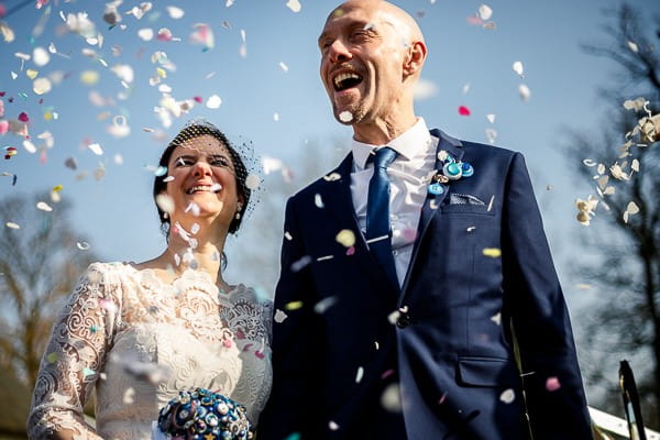 Bride and groom being showered in confetti