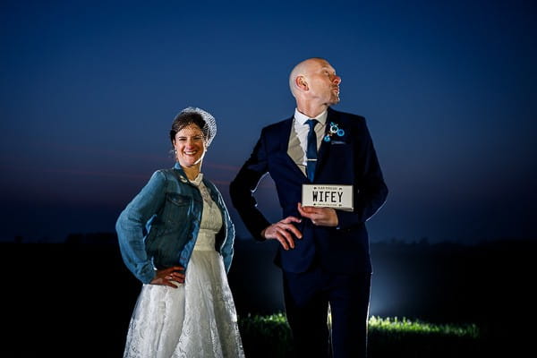 Groom doing funny pose holding wifey sign