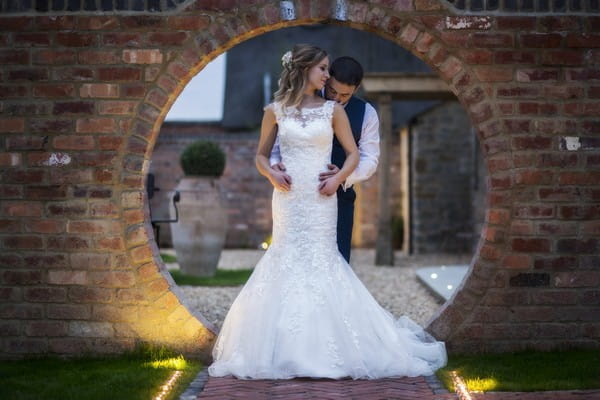 Bride and Groom in Front of Circle Hole in Wall at Blackwell Grange