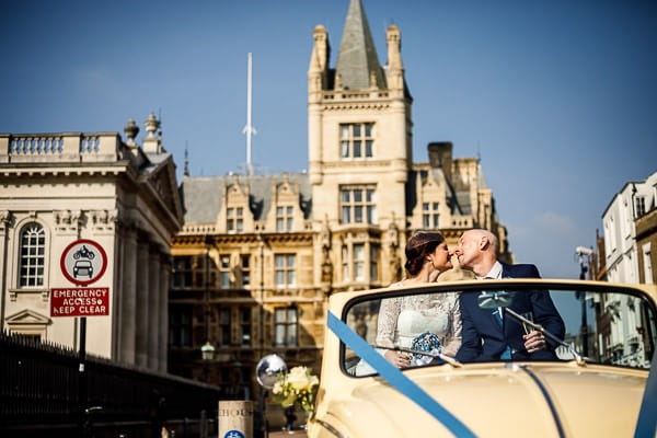 Bride and groom kissing in VW Beetle in Cambridge city centre