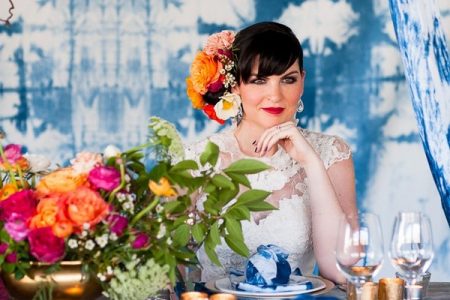 Bride sitting at wedding table with indigo Shibori backdrop