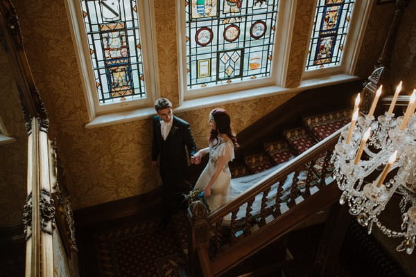 Bride and groom walking down stairs at Kilworth House