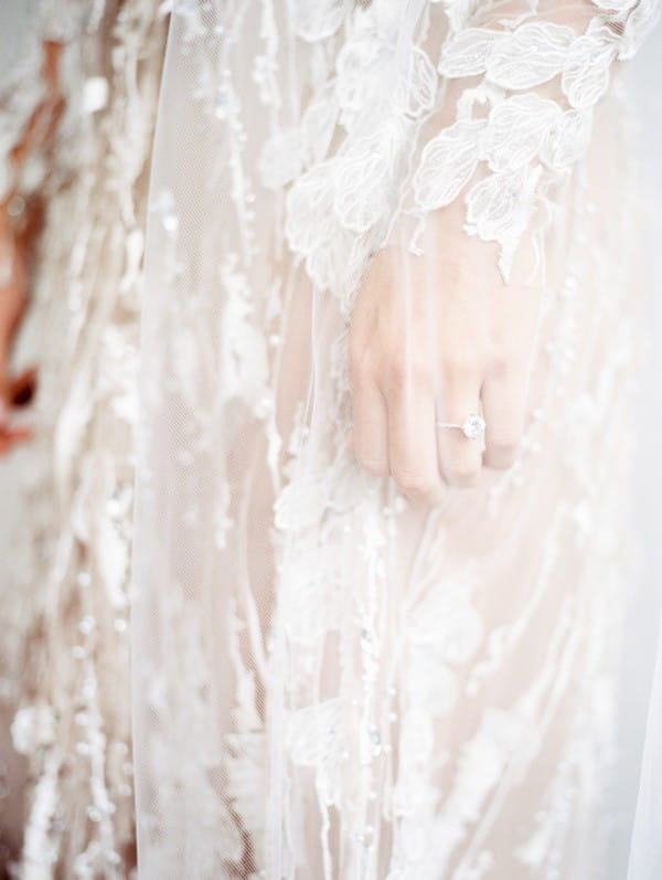 Ring on bride's finger under veil