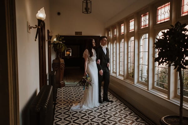 Bride and groom looking out of window at Kilworth House