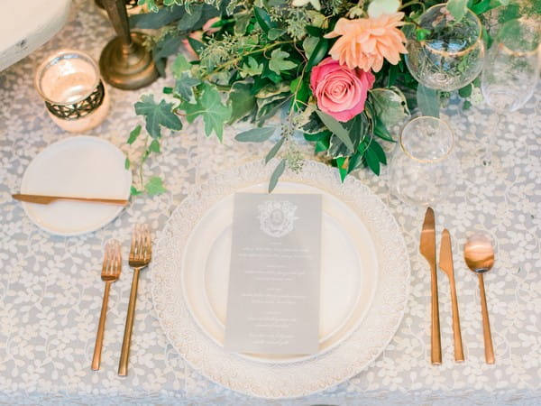 Grey wedding menu on plate with gold cutlery