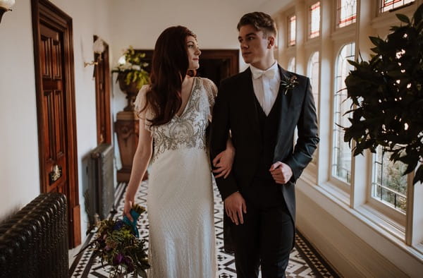 Bride and groom walking arm in arm through Kilworth House