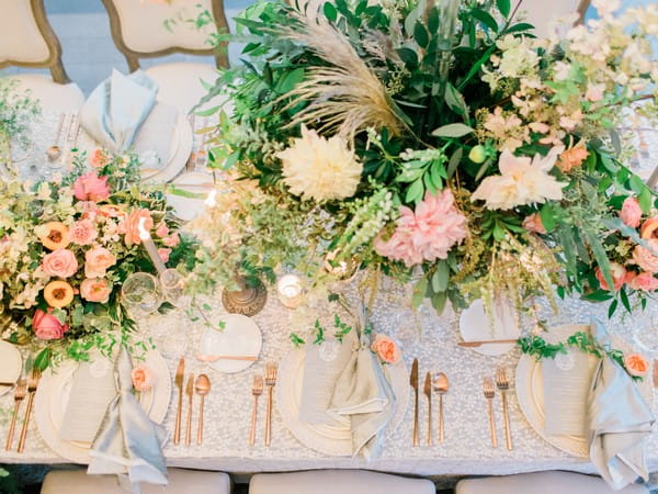 Wedding table styled with flowers, foliage and gold