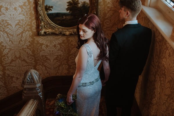 Back of bride and groom walking down stairs at Kilworth House