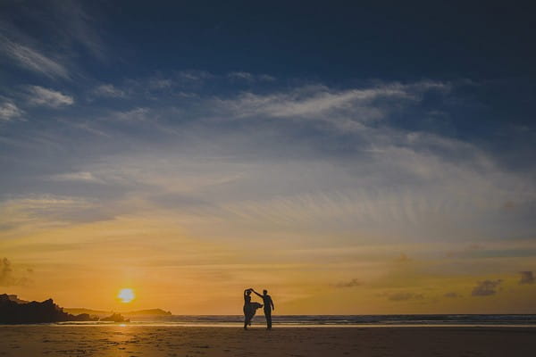 Silhouette of bride and groom dancing on beach at sunset - Picture by Abi Riley Photography