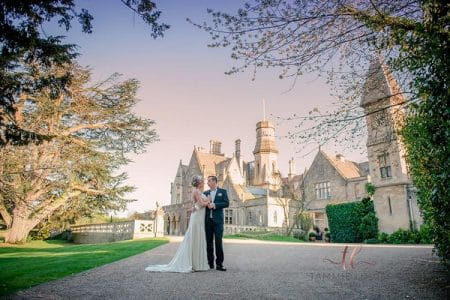 Bride and groom standing in front of Manor by the Lake - Picture by Tammie Louise Photography
