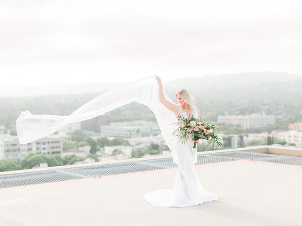 Bride with long cape blowing in wind