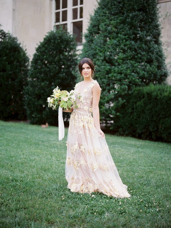 Bride on lawn holding bouquet