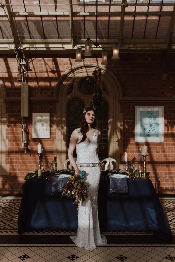 Bride standing in front of wedding table