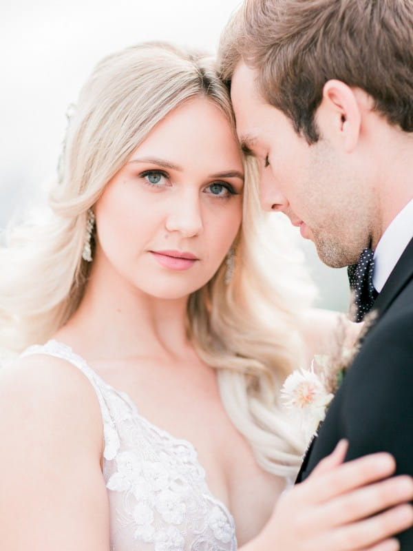 Groom resting head on bride's head