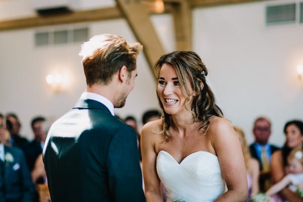 Bride and groom facing each other during wedding ceremony at Mythe Barn