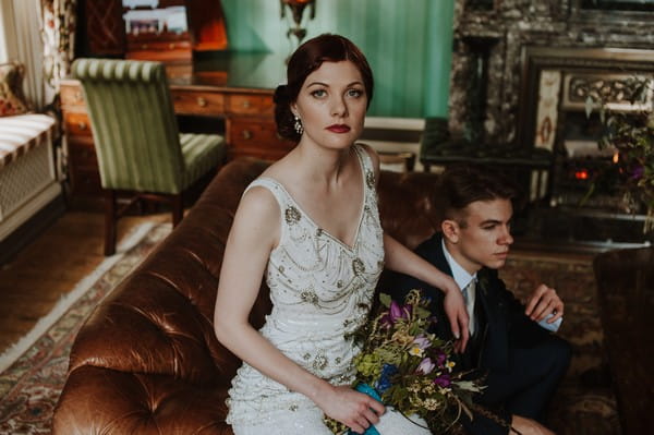 Groom sitting on arm of leather couch