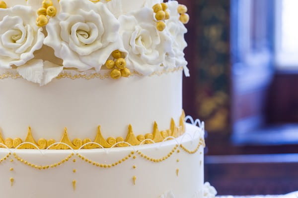 Sugar flowers and gold piping on wedding cake