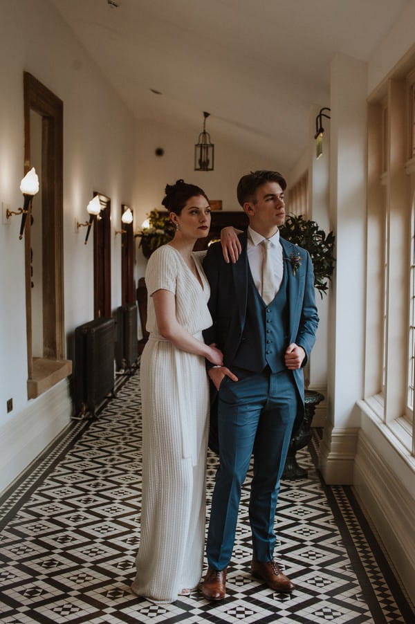 Bride and groom in corridor looking out of window at Kilworth House