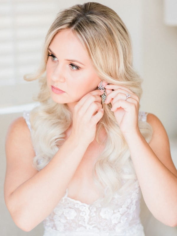 Bride putting on earrings