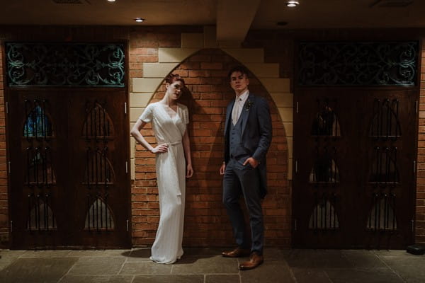 Bride and groom standing next to wall at Kilworth House