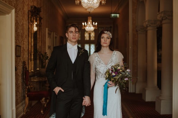 Bride and groom holding hands in hall of Kilworth House