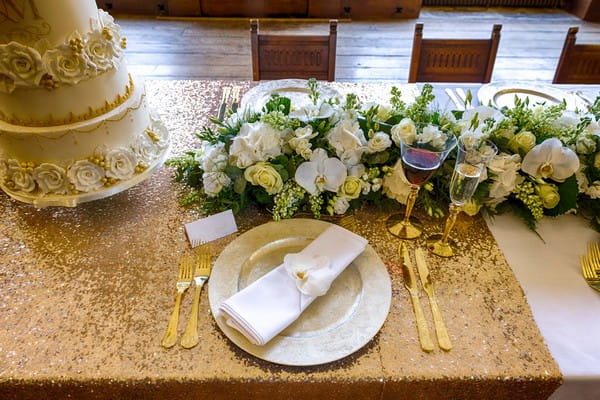 Wedding place setting on gold sequin tablecloth