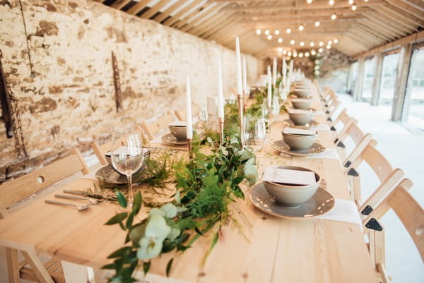 Long rustic wedding table with foliage table runner