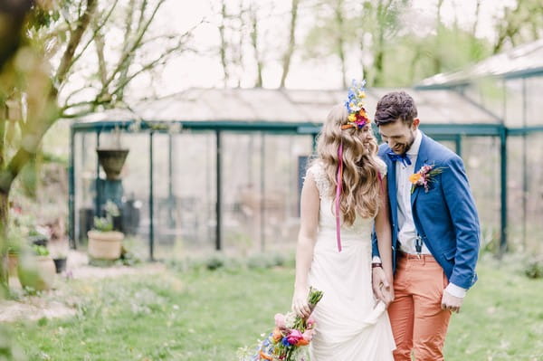 Boho bride walking with groom in woodland