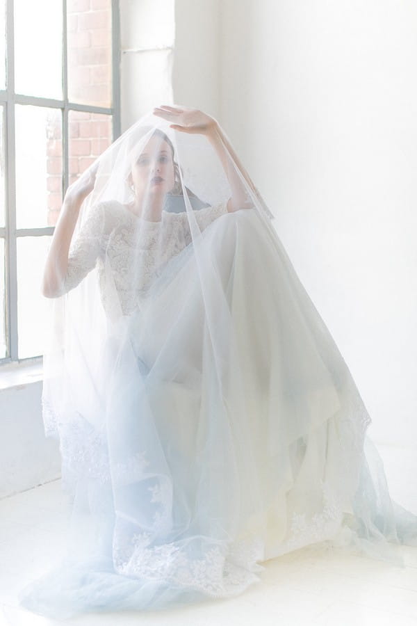 Bride sitting with veil over her head