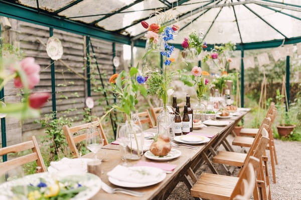 Rustic long long wedding table with colourful flowers