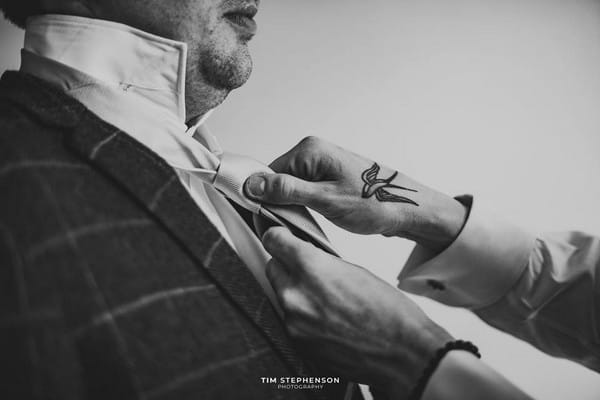 Hands doing up groom's tie - Picture by Tim Stephenson Photography