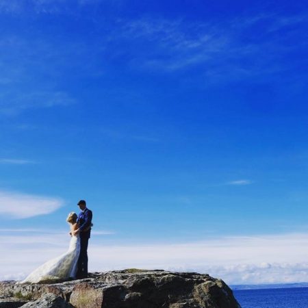 Bride and groom on top of cliff by sea - Picture by Ashley-Liv Jamieson Photography