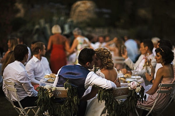 Bride and groom about to kiss at wedding breakfast table - Picture by Chris Barber Photography