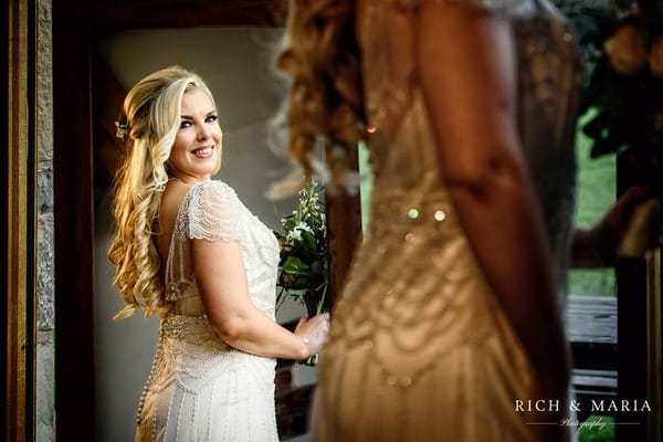 Bride looking at herself in the mirror - Picture by Rich and Maria Photography