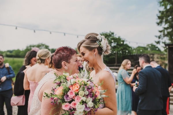 Bride with big smile as she stares into woman's eyes - Picture by The Struths