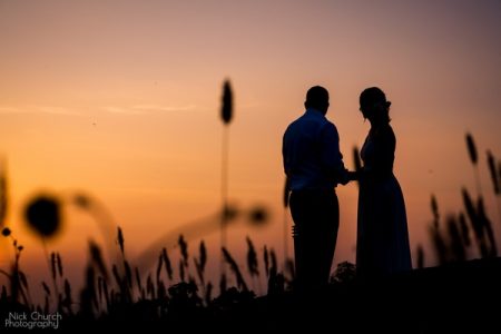 Bride and groom standing on hill at sunset - Picture by Nick Church Photography