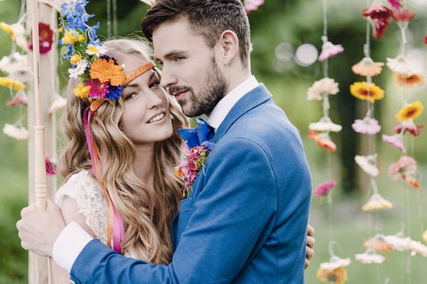 Bride with colourful floral headband and groom with blue jacket