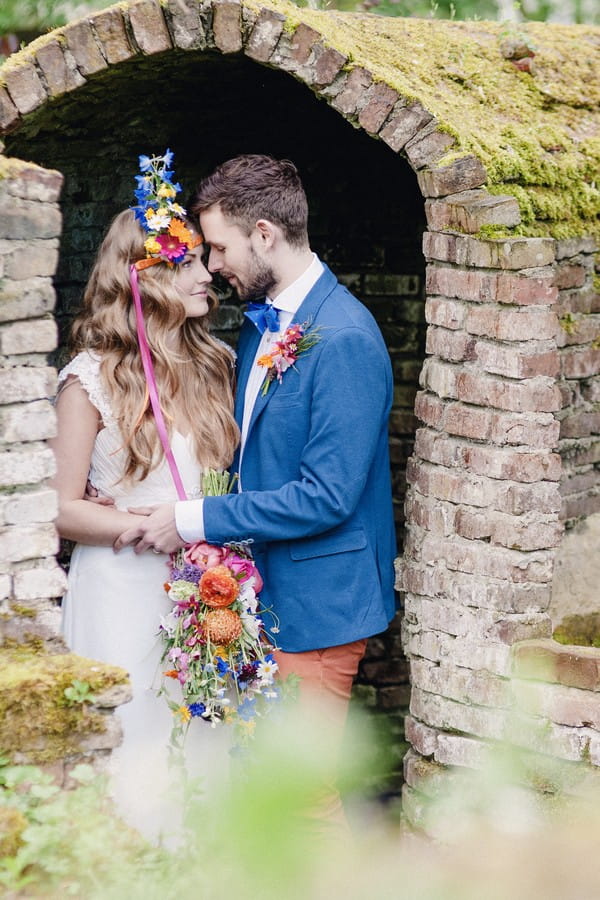 Bride and groom under brick arch