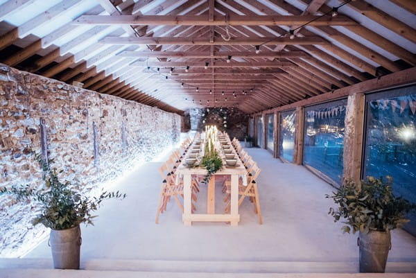 Long wedding tables in The Cowyard Barn at Pengenna Manor