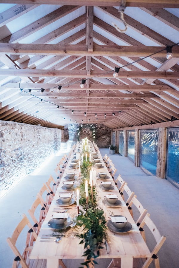 Long wedding tables in The Cowyard Barn at Pengenna Manor