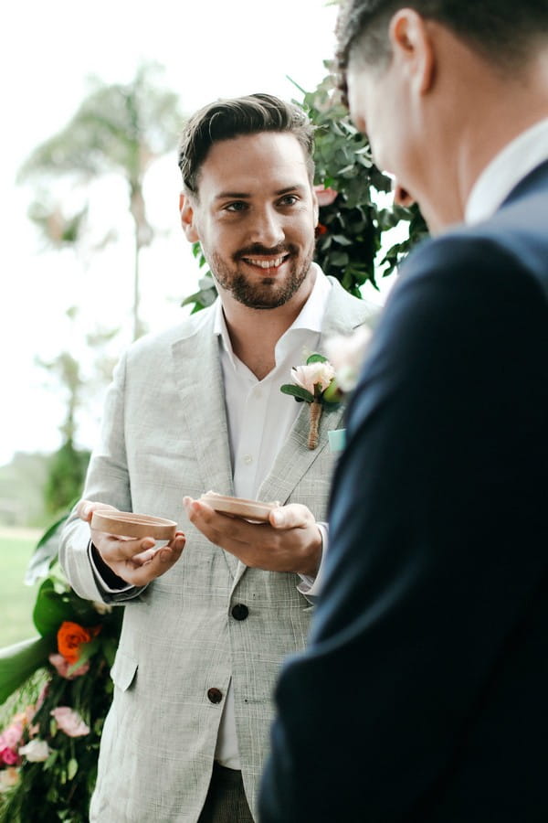 Best man giving groom wedding rings