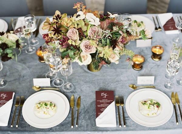 Wedding table styling with grey tablecloth and antique toned flowers