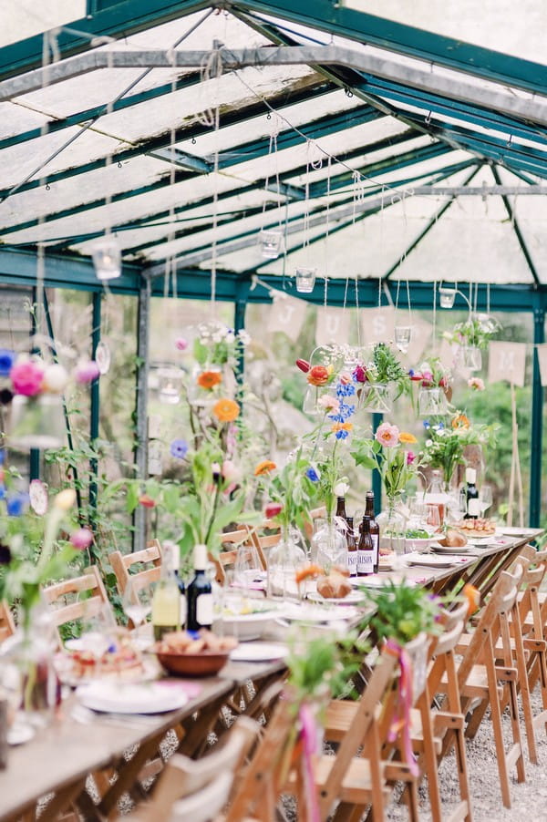 Colourful flowers hanging down over wedding table from string