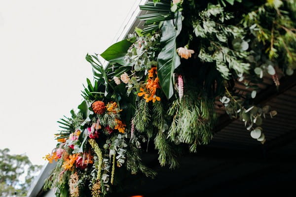 Flowers and foliage hanging from front of wedding barn