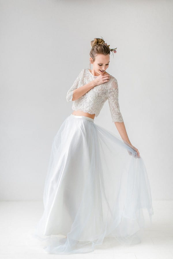 Bride holding out skirt of two-piece wedding dress
