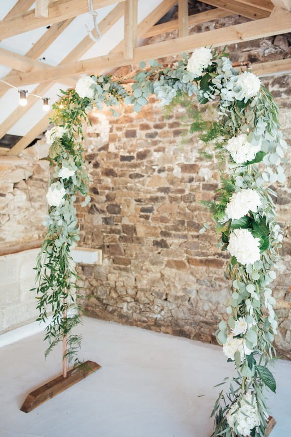 Wedding ceremony arch of white flowers and green foliage