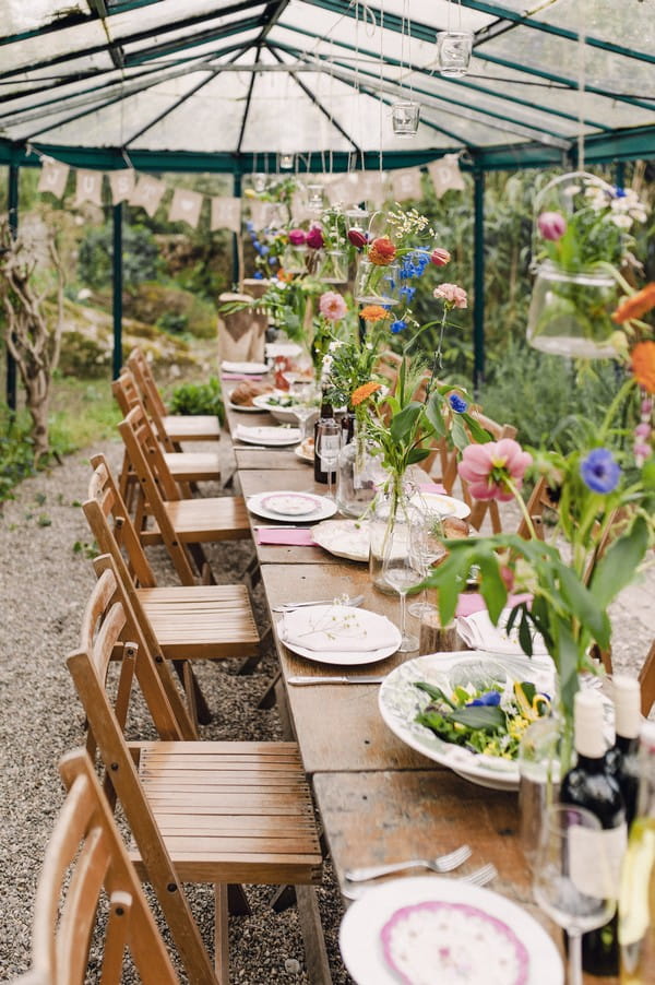 Rustic wedding table with colourful flowers hanging over