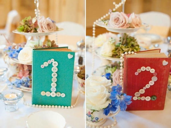 Wedding table centrepieces of books with numbers made from buttons
