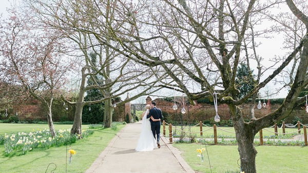 Bride and groom walking in Walled Garden at Gaynes Park